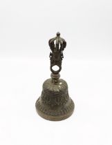 A Eastern 20th century cast brass bell with crown finial and masks to top, approx. 22cm high. Swag