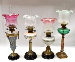 A small collection of four late 19th/early 20th century oil lamps, of various designs including; two