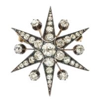 A Victorian diamond set star burst pendant/ brooch, the central stone weighing approx 0.55ct,