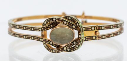 A 19th century champlevé enamel and gold mourning bangle, comprising a central knot inset with a