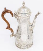 A George III silver coffee pot, baluster shaped engraved with scrolling foliage, the spout with