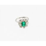 An emerald and diamond white metal ring, the emerald cut emerald measuring approx 8 x 6 x 3.5mm,