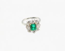 An emerald and diamond white metal ring, the emerald cut emerald measuring approx 8 x 6 x 3.5mm,