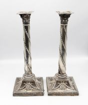 A pair of George III silver candlesticks, Corinthian capital above plain columns chased with husk