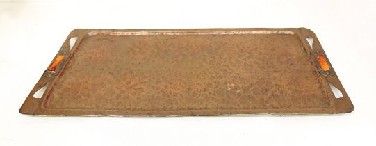 An Arts & Crafts hammered / planished copper two handled rectangular tray, the handles applied