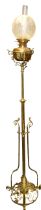A late 19th century tall extendable ornate brass columned standing oil lamp, the base having central