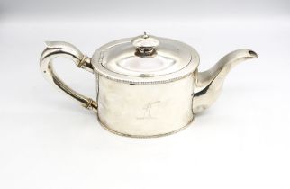 A George III silver teapot of oval shape with beaded borders, curved silver handle and silver