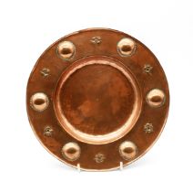 Dryad Lester - an Arts & Crafts copper circular footed dish with embossed roundel style and floral