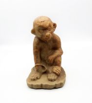 An early 20th century fire clay model of a monkey, detailed facial features, approx. 23.5cm high.
