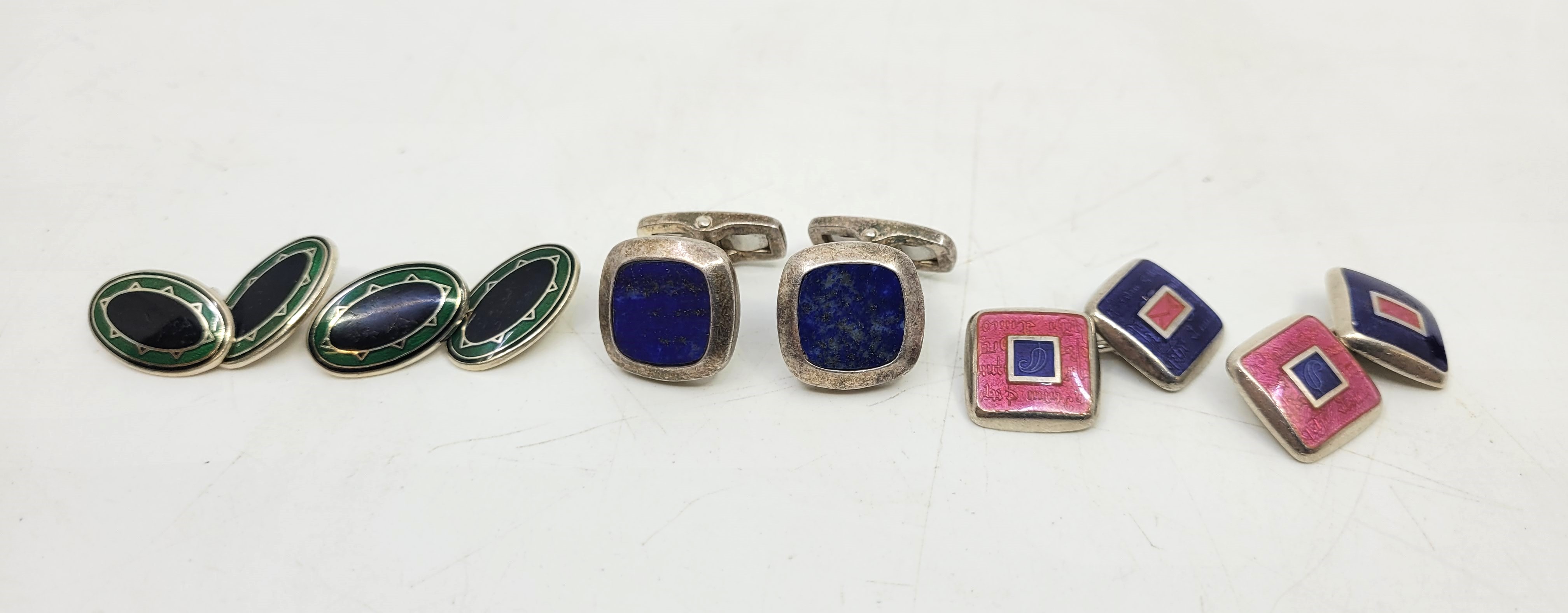 Three pairs of silver mounted cufflinks, to include; a pair of oval silver, green guilloche enamel
