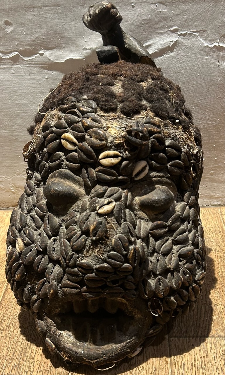 A 20th Camaroon mask decorated with cowrie shells , and a later 20th cent mask