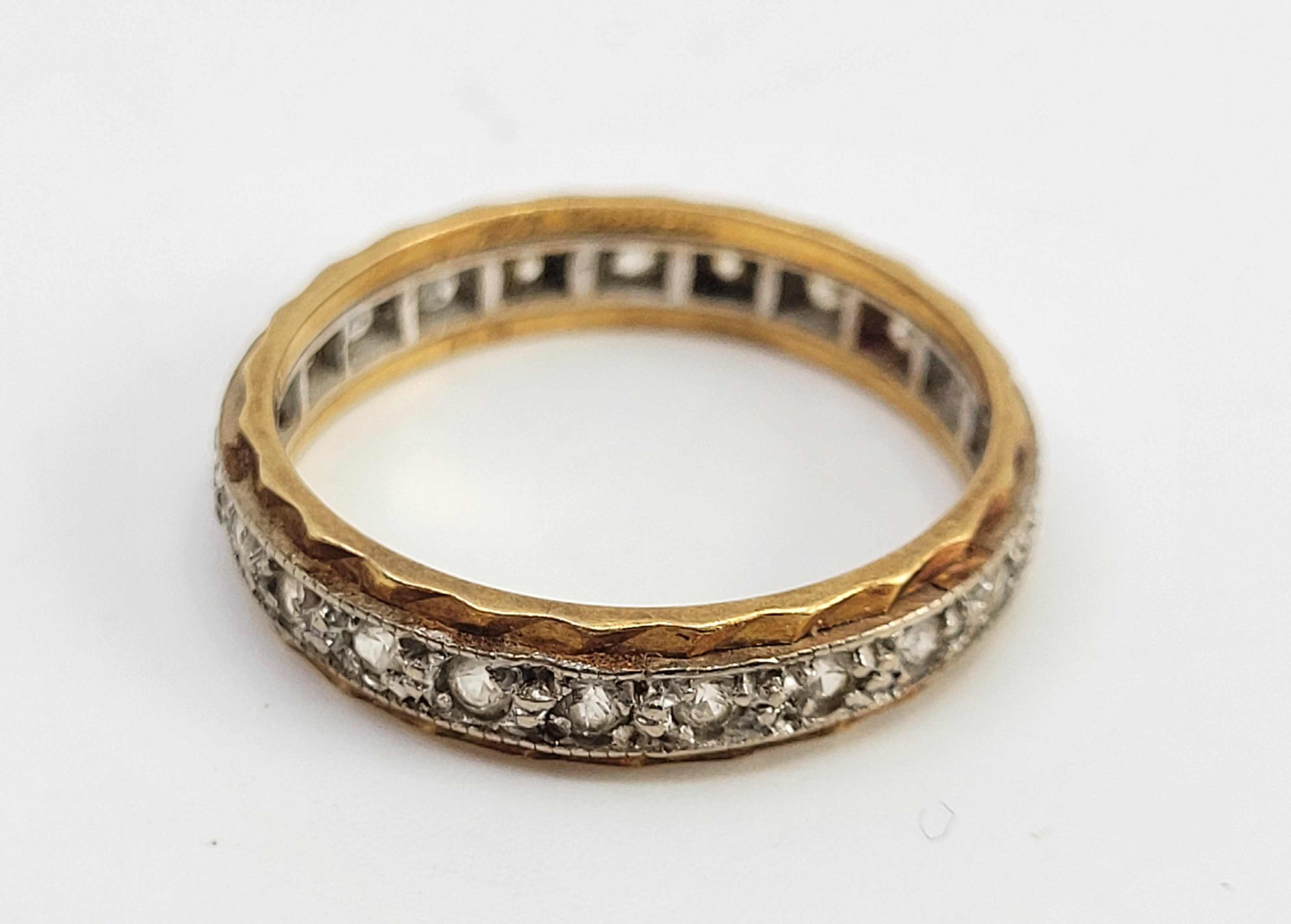 An 18ct. bi-colour gold and diamond eternity ring, set numerous round brilliant cut diamonds, size