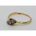 An 18ct. gold three stone diamond cross-over style ring, set row of three graduated diamonds (the