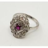An 18ct. white gold, diamond and ruby ring, in the Art Deco style, having lobed oval mount set mixed