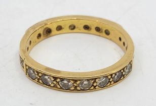 A precious yellow metal diamond eternity ring, flush set fourteen round brilliant-cut diamonds of