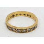 A precious yellow metal diamond eternity ring, flush set fourteen round brilliant-cut diamonds of