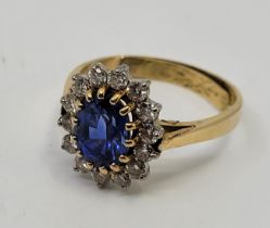 An 18ct. gold, sapphire and diamond cluster ring, having oval mount set oval mixed cut sapphire to