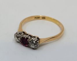 An 18ct. gold, platinum, diamond and ruby ring, set round mixed cut ruby to centre flanked by old-