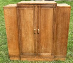 An early 1920s Heals limed oak cabinet,  Heals circular ivorine seal inside