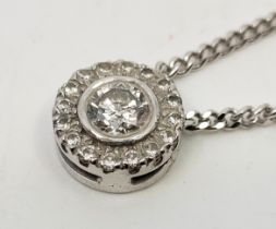 A 9ct. white gold diamond pendant necklace, the circular pendant set central round brilliant cut