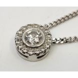 A 9ct. white gold diamond pendant necklace, the circular pendant set central round brilliant cut