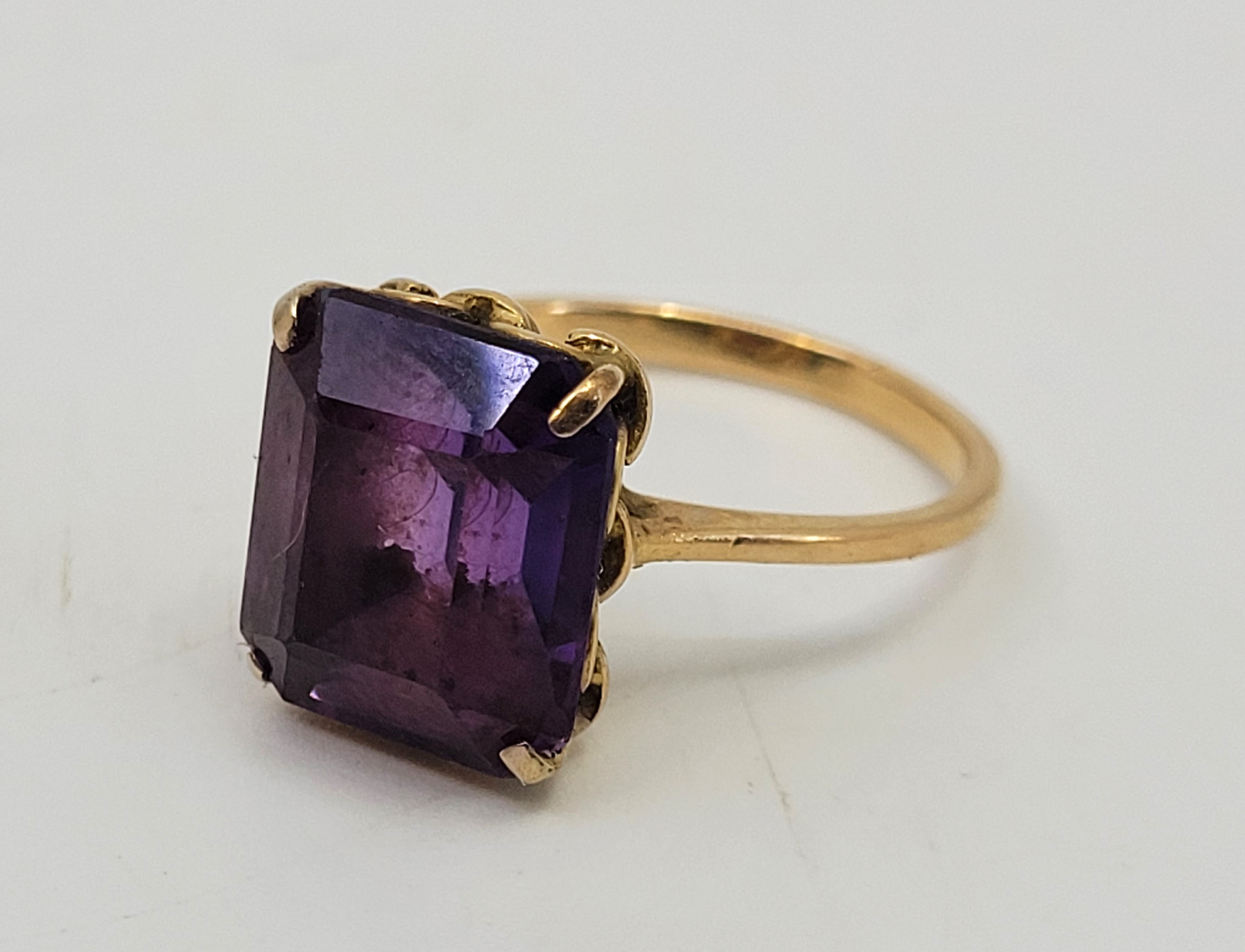 A precious yellow metal and amethyst cocktail ring, set mixed rectangular cut amethyst (yellow metal