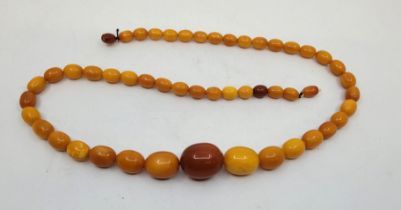 A string of graduated oval butterscotch amber beads, the largest bead to centre length 30mm x