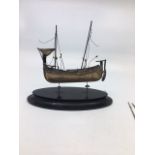 A 20th century Asian white metal model of a junk boat, (white metal assessed as silver), mounted