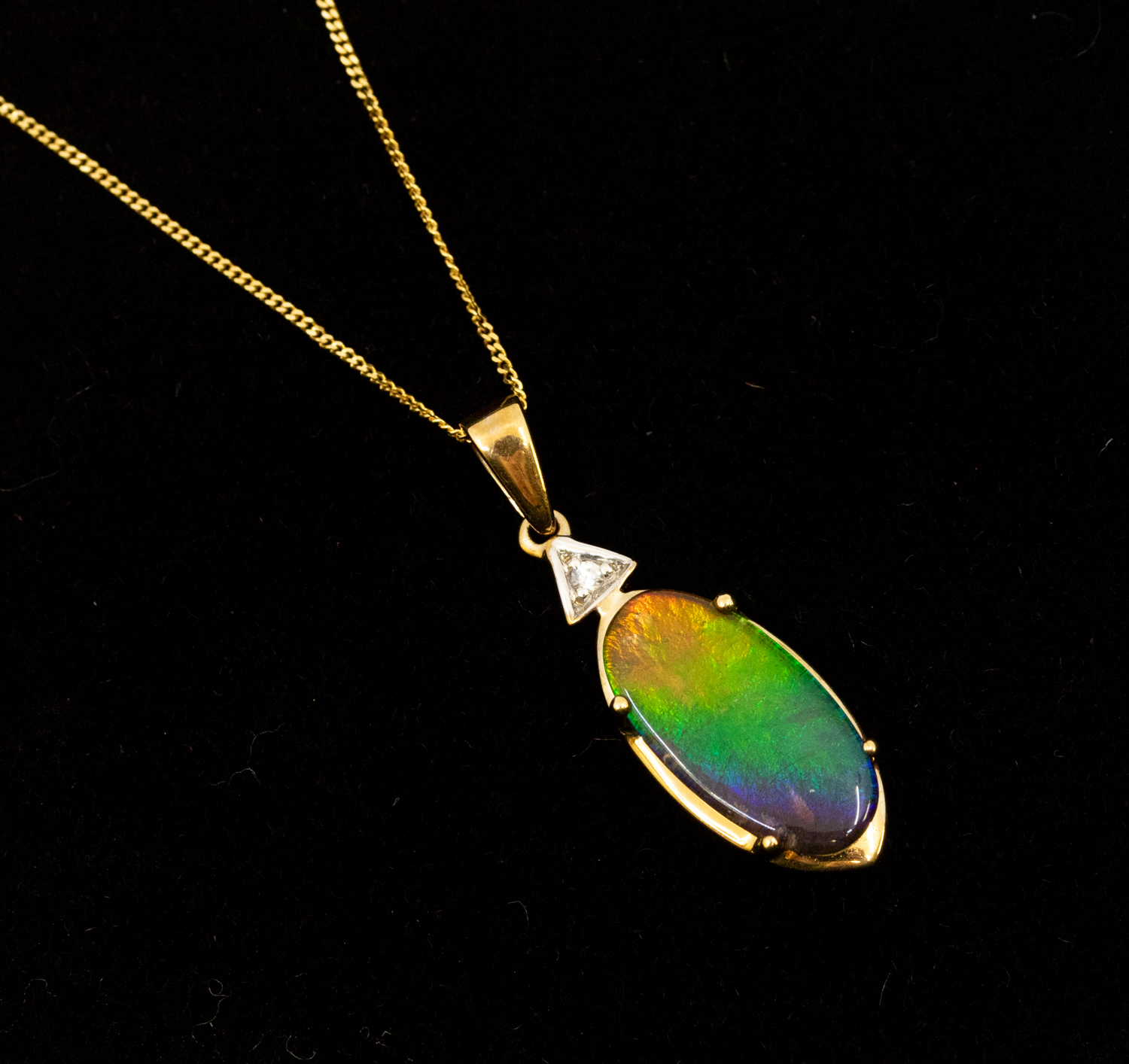 An ammolite and diamond set 9ct gold pendant, comprising an oval claw set ammolite approx 15 x