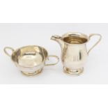 A matched George V silver milk jug and twin handled sugar bowl, both on circular footed bases,