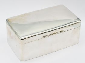 A large George V plain silver cigarette box of slightly domed form, interior cover gilt with twin