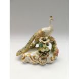 Royal Crown Derby porcelain figure of a peacock.