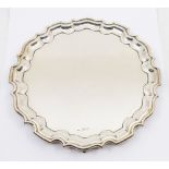 A late Edwardian silver salver, three scrolled feet and pie crust edging, hallmarked by Walker &