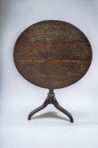 A 19th century oak round tilt top table with tripod legs.