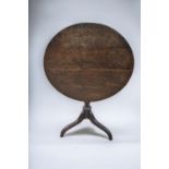 A 19th century oak round tilt top table with tripod legs.