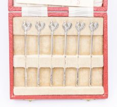 A cased set of six novelty Queen Elizabeth II silver cocktail sticks, cockerel shaped terminals,