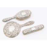A Queen Elizabeth II three piece silver dressing table set consisting of mirror, hand brush and