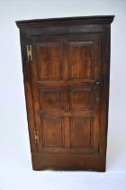 A solid oak George I hall cupboard with plain panel front and sides, doors open to reveal hanging