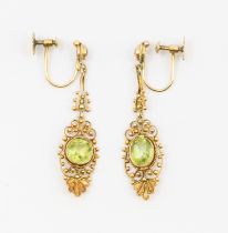 A pair of peridot and gold earrings, mismatched comprising a round and oval mixed cut peridot within