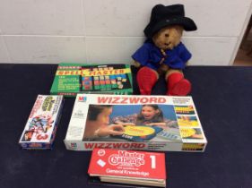 A collection of vintage childrens games along with a Paddington bear.