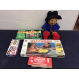 A collection of vintage childrens games along with a Paddington bear.