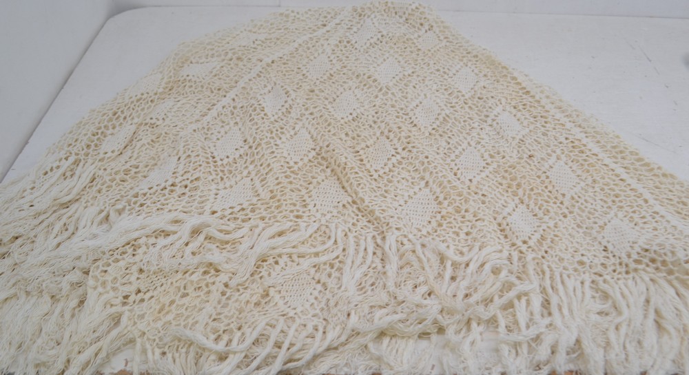 A crochet cream shawl in cream.