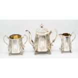 A Victorian Gothic style three piece tea set consisting of tea pot, milk jug and a twin handled