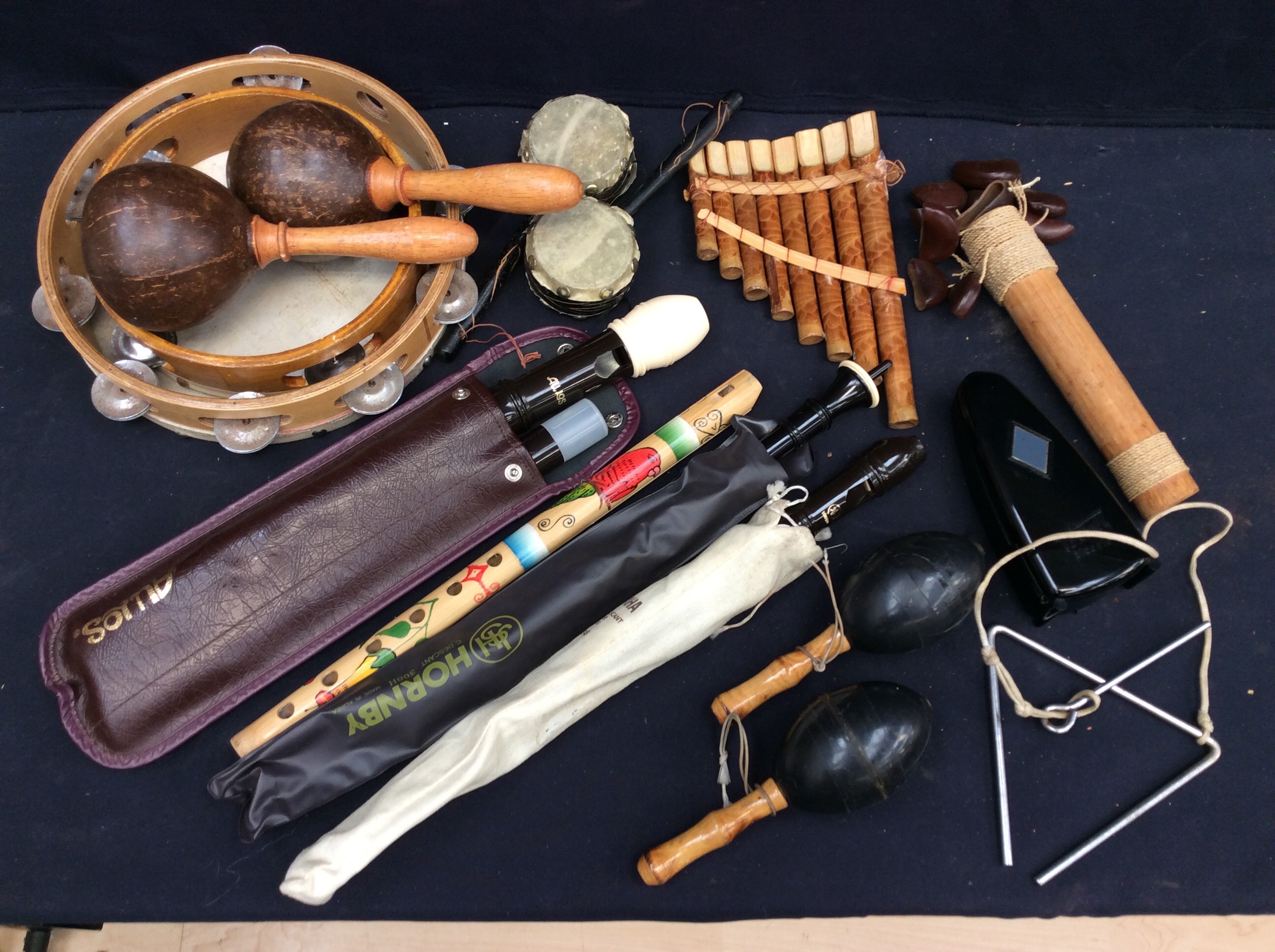 A collection of musical instruments to include recorders, tambourines, pan pipes, triangle,