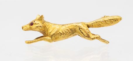A ruby set 9ct gold brooch, carved in the form of a running fox, the eyes set with small rubies,