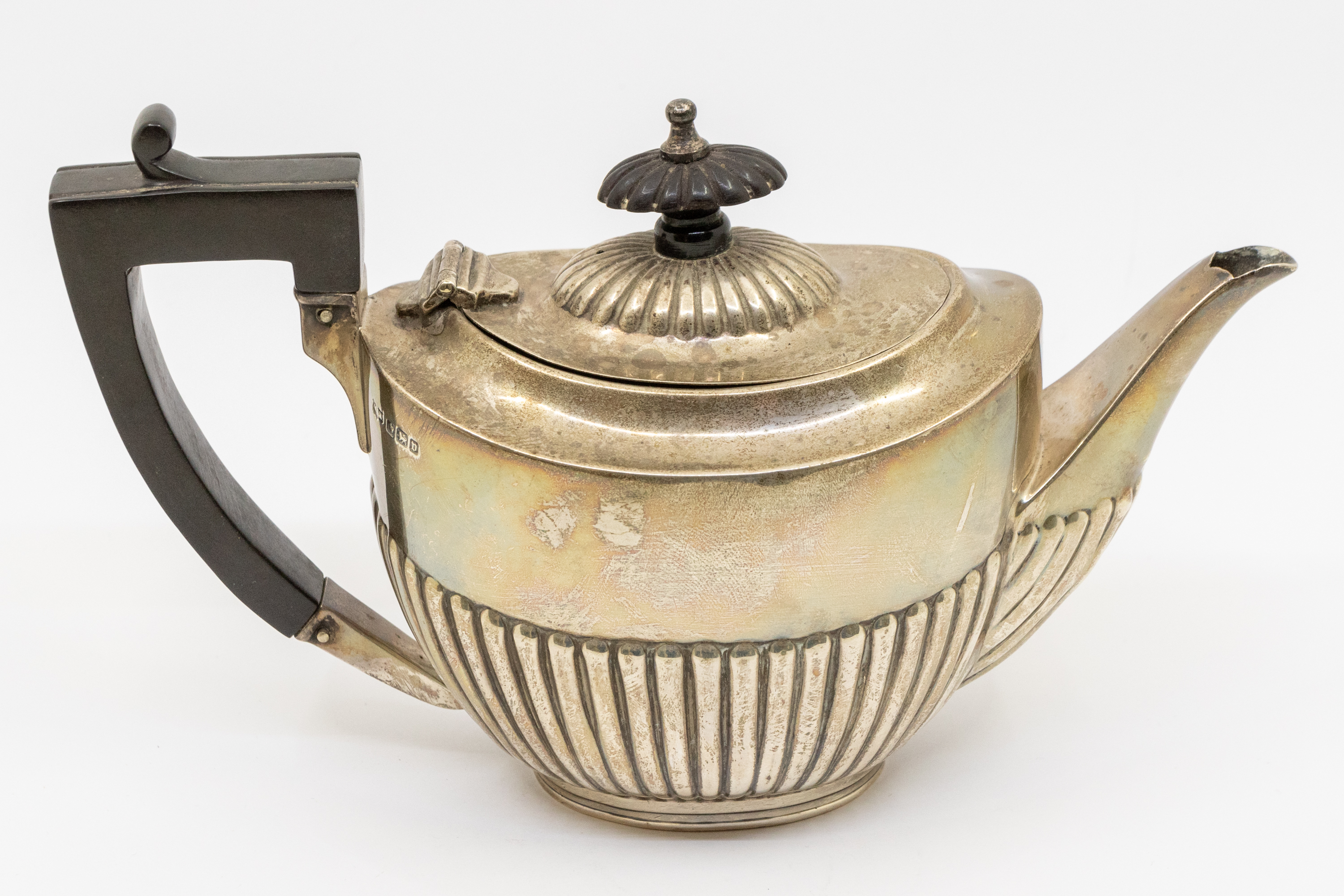A George V silver bachelor's teapot, gadrooned lower section, ebony handle and finial, hallmarked
