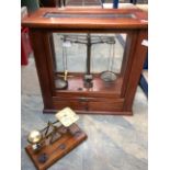 A 19th Century laboratory scales in glazed mahogany case with weights in cabinet drawer along with