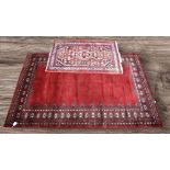 A mid 20th Century deep red hand knotted Pakistani rug with crab border detail aong with a small