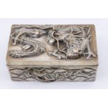 A Chinese silver cigarette box, with relief dragon design to top and all sides, slight planishing to