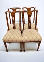 Four Edwardian inlayed dining chairs in mahogany with padded seats.